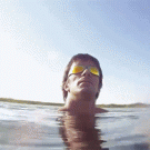 Close paraglider fly-by over water
