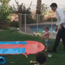 Dad helps kid with slip 'n slide
