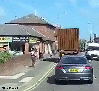 woman-almost-hit-in-head-by-turning-truck.gif