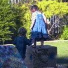 Boy pushes girl off box