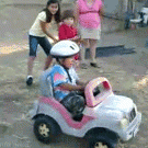 Kid pushed downhill in his car