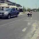 Kid does wheelie with dad's help