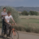 Napoleon and Pedro riding the bike