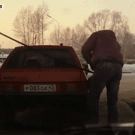 Russian guy lifts car at gas station