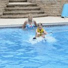 Dog jumps on girl in swimming pool