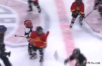 referee carries goalie across ice, children playing hockey