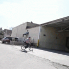 Tim Knoll biking under truck containers