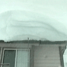 Guy pulls snow off rooftop on himself
